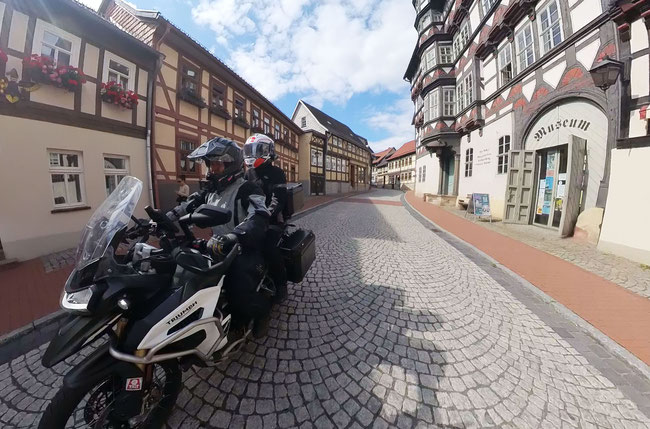 Zwei Menschen auf einem Motorrad, fahrend durch die Fachwerkstadt Stolberg.
